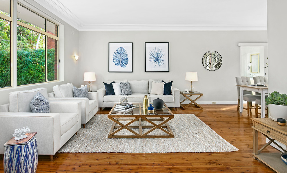 Foto de salón abierto tradicional renovado pequeño con paredes grises, suelo de madera en tonos medios y televisor independiente