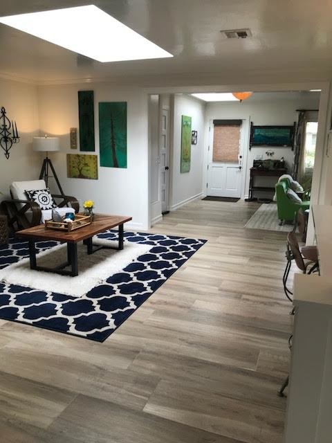 Großes, Repräsentatives, Fernseherloses, Offenes Modernes Wohnzimmer mit weißer Wandfarbe, hellem Holzboden, braunem Boden, Kamin und Kaminumrandung aus Backstein in San Diego