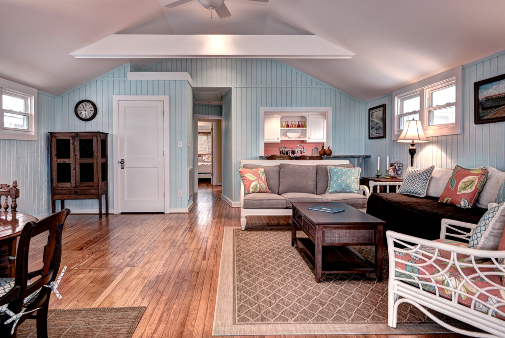На фото: открытая гостиная комната среднего размера в морском стиле с синими стенами, паркетным полом среднего тона и коричневым полом без камина, телевизора