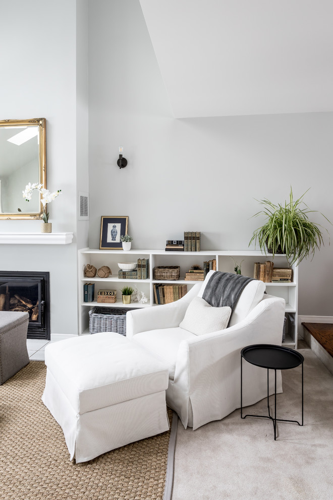 Idée de décoration pour un grand salon tradition ouvert avec une cheminée standard, un manteau de cheminée en plâtre, un mur gris, un téléviseur indépendant et un sol blanc.