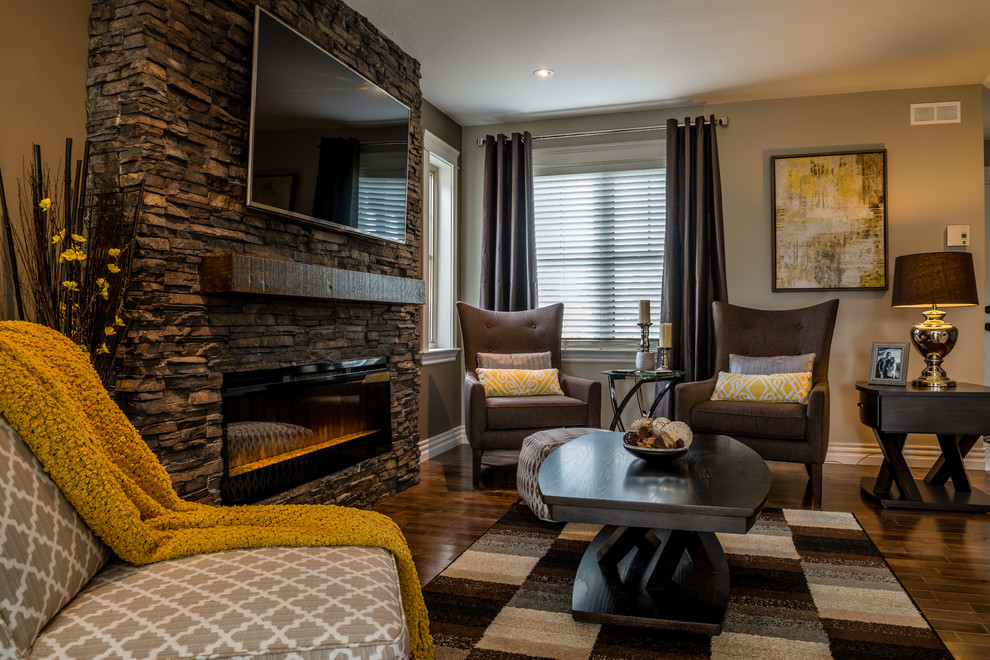 Inspiration pour un grand salon traditionnel ouvert avec un mur gris, une cheminée standard, un manteau de cheminée en pierre, un téléviseur fixé au mur et un sol marron.