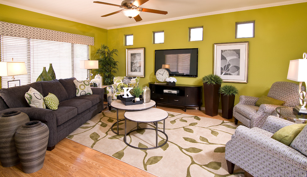 Esempio di un soggiorno minimal di medie dimensioni e aperto con pareti verdi, TV a parete e parquet chiaro