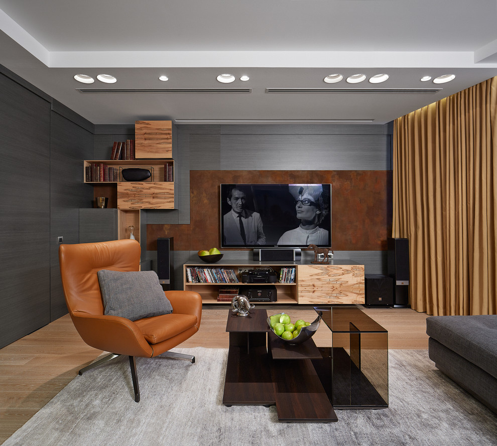 Стильный дизайн: гостиная комната в современном стиле с серыми стенами, светлым паркетным полом и телевизором на стене без камина - последний тренд