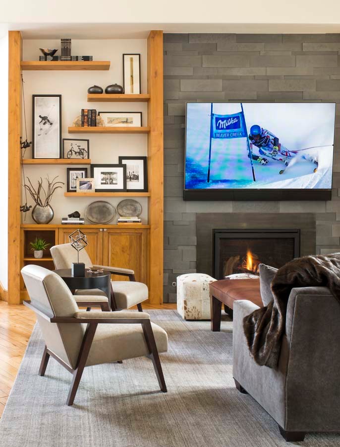 Design ideas for a large modern mezzanine living room in Denver with white walls, medium hardwood flooring, a standard fireplace, a stone fireplace surround and a wall mounted tv.