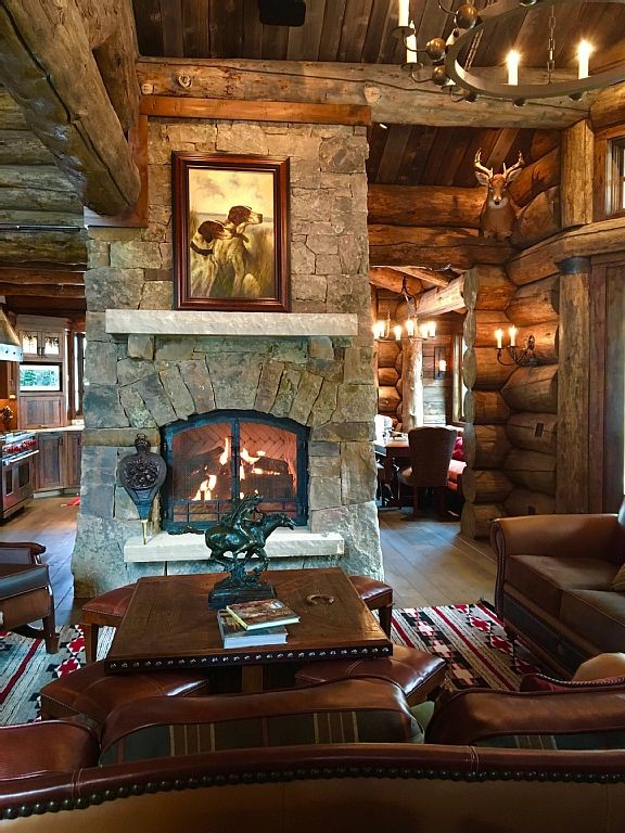 Inspiration for a mid-sized rustic formal and open concept light wood floor living room remodel in Denver with brown walls, a standard fireplace, a stone fireplace and no tv
