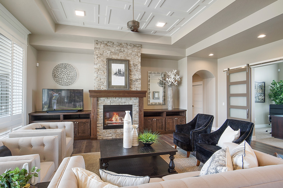 Klassisches Wohnzimmer mit beiger Wandfarbe, dunklem Holzboden, Kamin, Kaminumrandung aus Backstein und braunem Boden in Boise