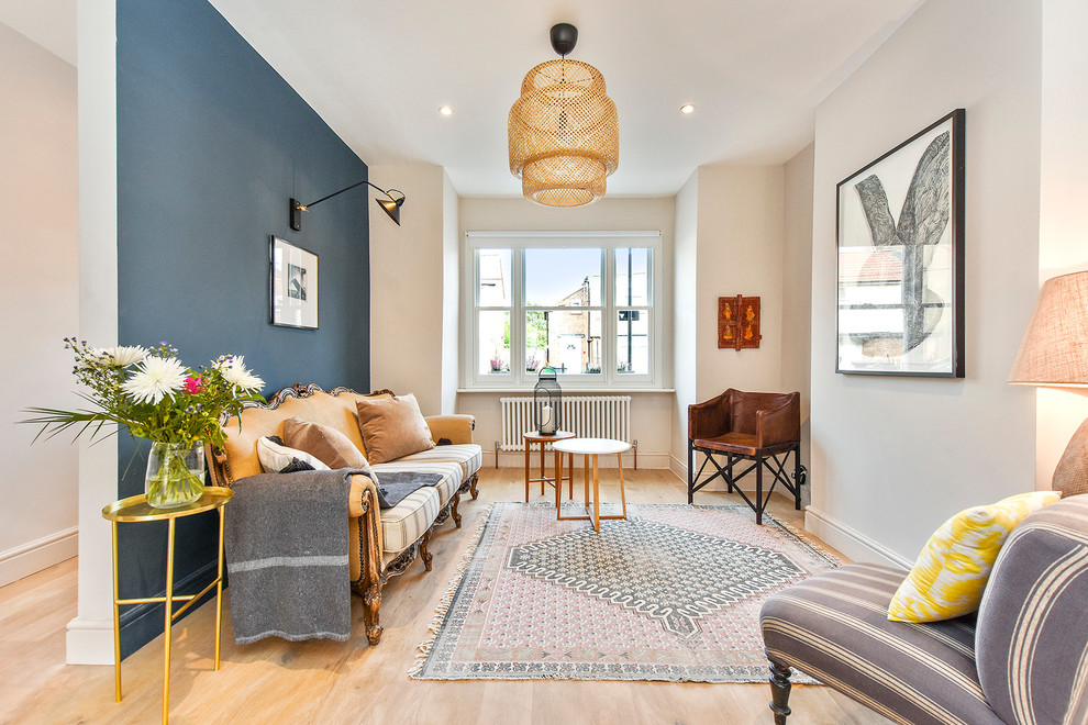 Mid-sized eclectic light wood floor living room photo in London with blue walls