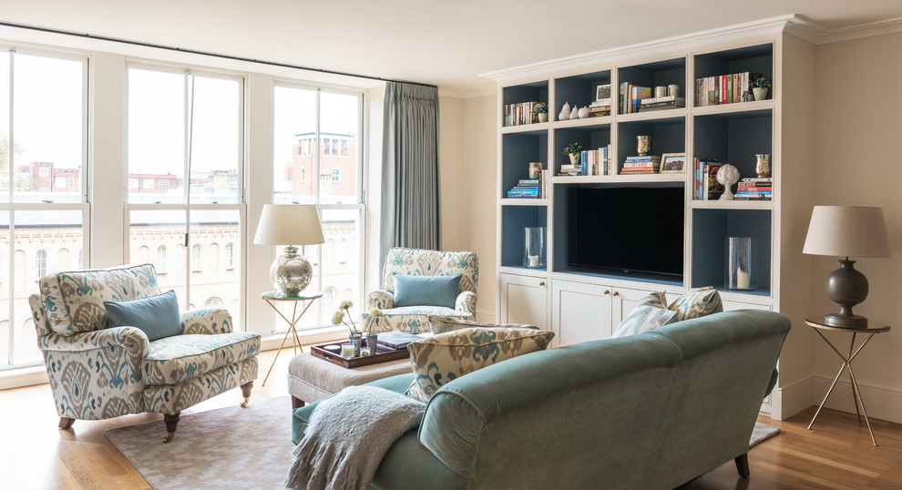 This is an example of a medium sized classic open plan living room in London with beige walls, light hardwood flooring and a built-in media unit.