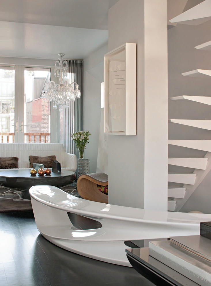 Свежая идея для дизайна: гостиная комната в современном стиле с белыми стенами и черным полом - отличное фото интерьера