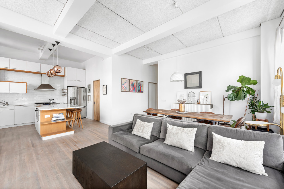 Mittelgroßes Eklektisches Wohnzimmer im Loft-Stil mit weißer Wandfarbe, braunem Holzboden, Kamin, verputzter Kaminumrandung, TV-Wand, grauem Boden und freigelegten Dachbalken in New York