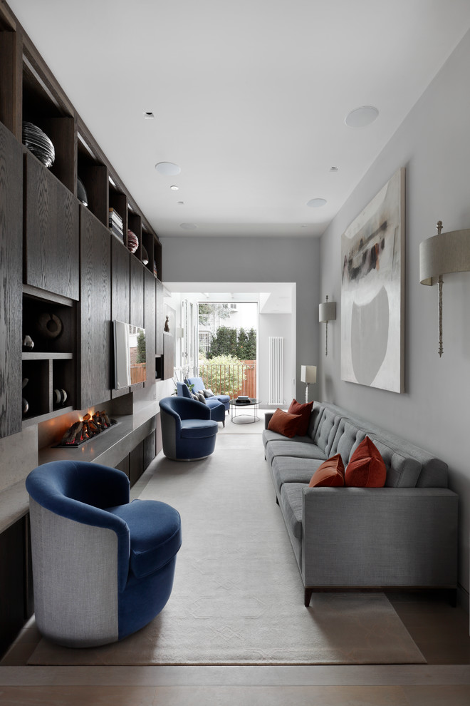 This is an example of a medium sized contemporary living room in London with white walls, a concrete fireplace surround, a wall mounted tv and beige floors.