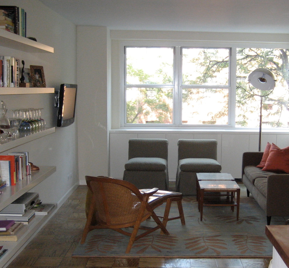 Foto de biblioteca en casa abierta retro de tamaño medio sin chimenea con paredes blancas, suelo de madera en tonos medios, televisor colgado en la pared y suelo marrón
