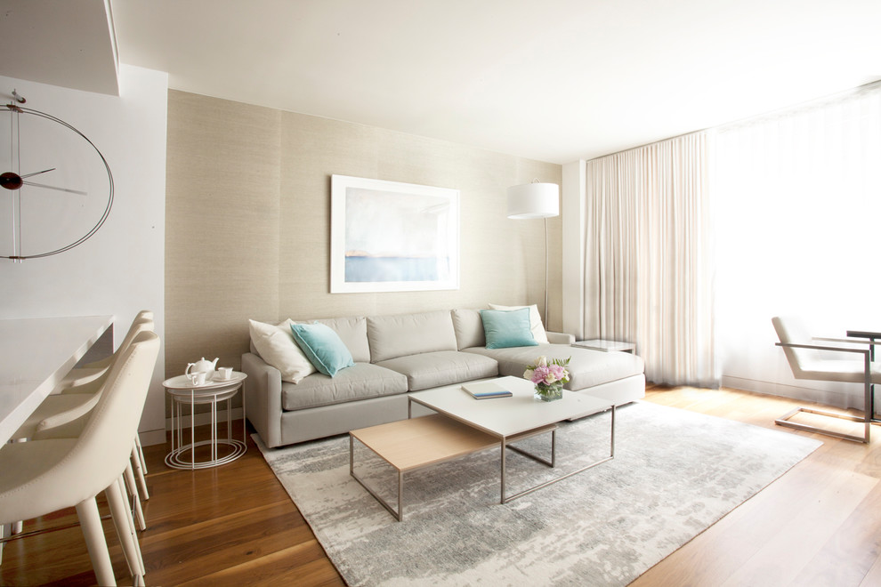 Foto de salón abierto minimalista de tamaño medio con suelo de madera en tonos medios y televisor colgado en la pared