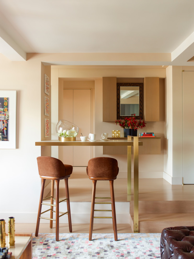 Idée de décoration pour un salon design ouvert et de taille moyenne avec un mur beige et parquet clair.