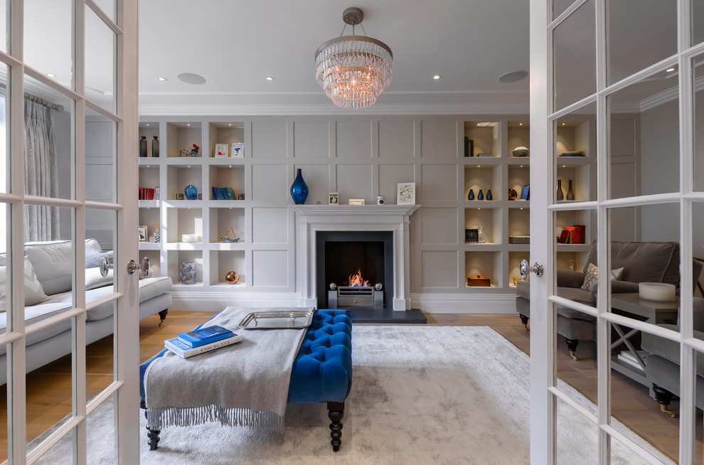 Large transitional formal and enclosed medium tone wood floor and brown floor living room photo in London with gray walls, no tv and a standard fireplace