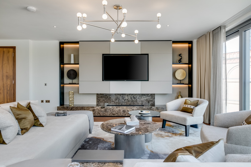 This is an example of a large contemporary living room in London with white walls, medium hardwood flooring, a wall mounted tv and brown floors.