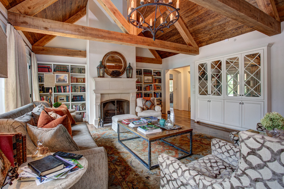 Living room library - large farmhouse enclosed medium tone wood floor and brown floor living room library idea in Little Rock with white walls, a standard fireplace, a stone fireplace and no tv