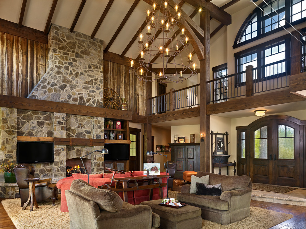 This is an example of a large classic formal open plan living room in Denver with beige walls, medium hardwood flooring, a standard fireplace, a stone fireplace surround and a wall mounted tv.