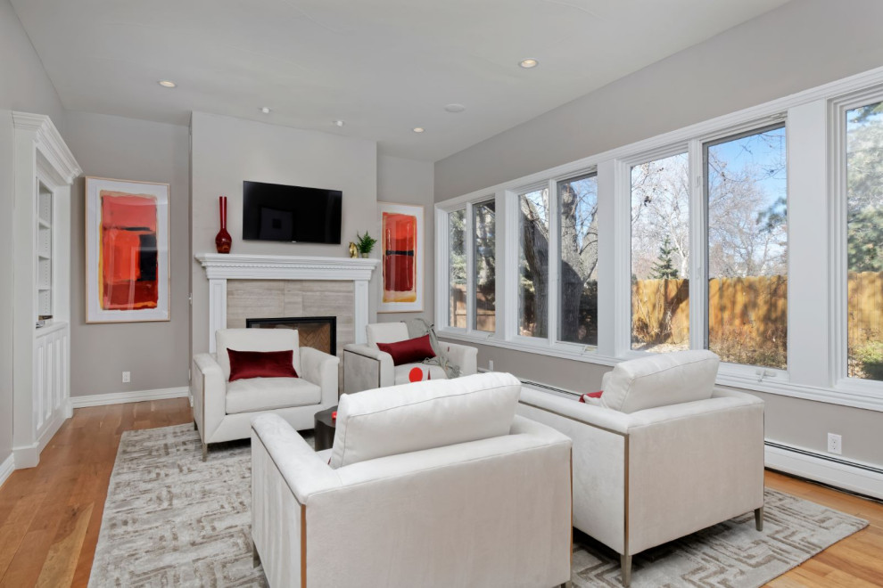 Foto di un soggiorno minimal di medie dimensioni e chiuso con sala formale, pareti grigie, pavimento in legno massello medio e TV a parete