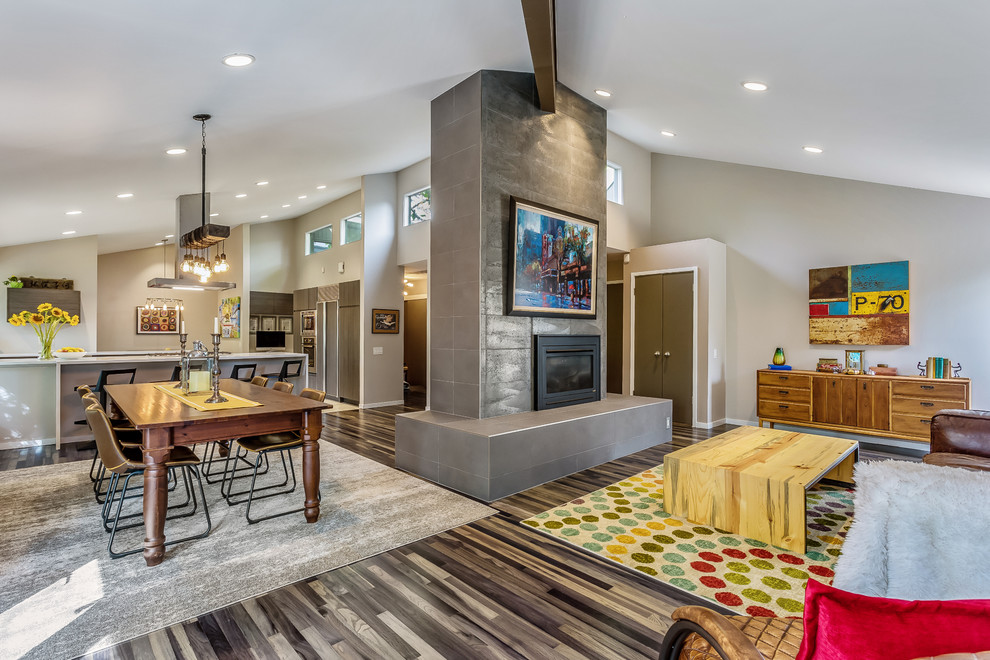 Offenes Modernes Wohnzimmer mit grauer Wandfarbe, dunklem Holzboden, Kamin, gefliester Kaminumrandung und braunem Boden in Denver