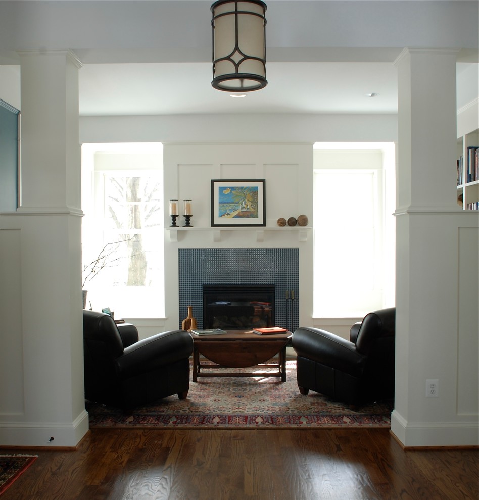 Aménagement d'un salon craftsman de taille moyenne et fermé avec un mur blanc, un sol en bois brun, une cheminée standard, un manteau de cheminée en carrelage et une salle de réception.