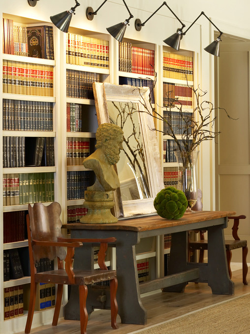 Imagen de biblioteca en casa ecléctica de tamaño medio con paredes blancas y suelo de madera en tonos medios