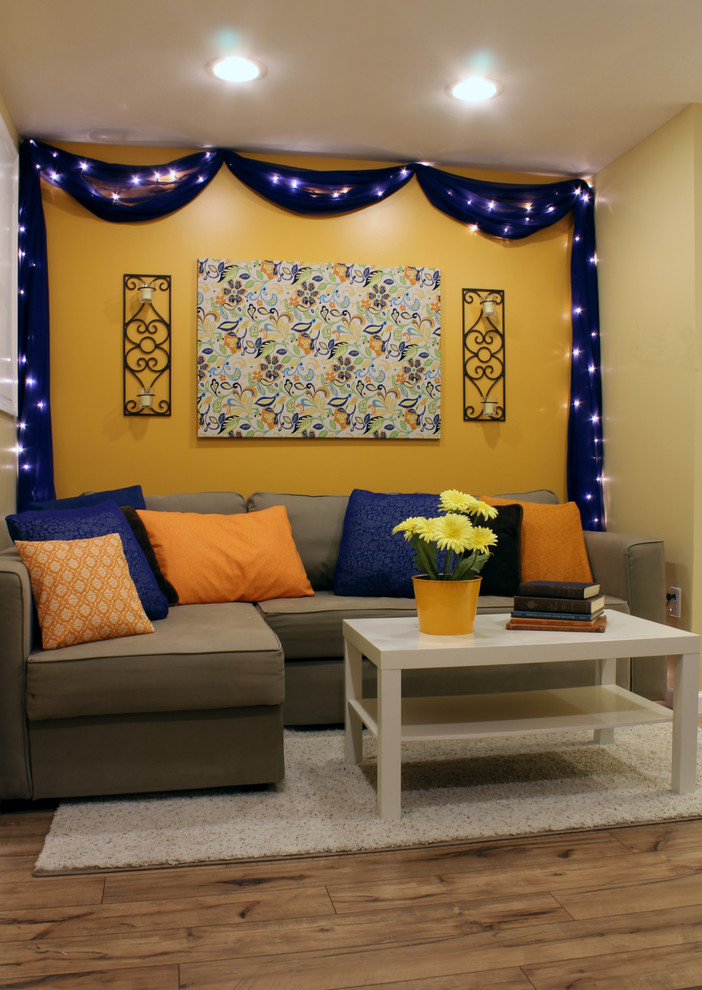 Источник вдохновения для домашнего уюта: маленькая гостиная комната в современном стиле с оранжевыми стенами и полом из ламината для на участке и в саду