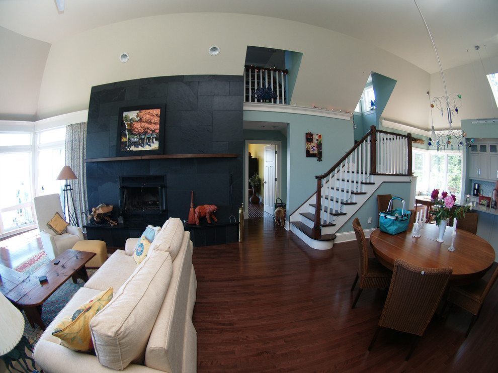 Photo of a medium sized traditional open plan living room in Other with blue walls, dark hardwood flooring, a standard fireplace, a stone fireplace surround, no tv and brown floors.