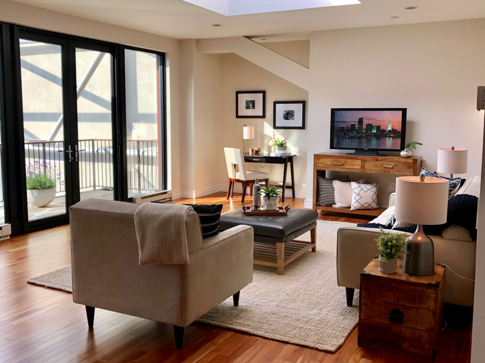 Inspiration for a large eclectic open concept medium tone wood floor and brown floor living room remodel in Boston with a tv stand and beige walls