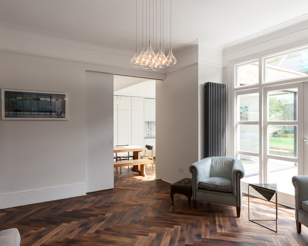 Diseño de salón actual con paredes grises, suelo de madera en tonos medios y suelo marrón