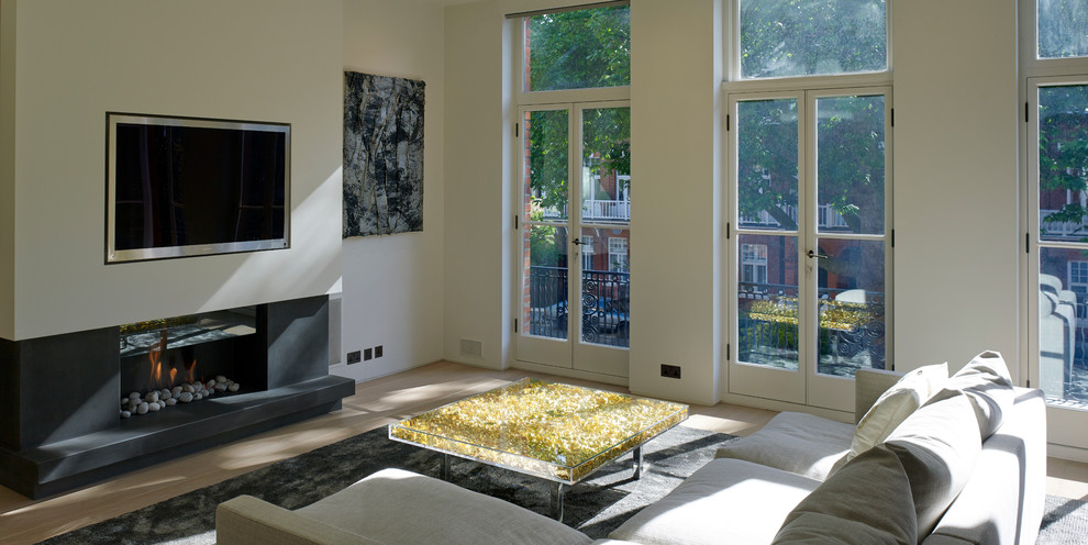 На фото: открытая гостиная комната среднего размера в современном стиле с белыми стенами, светлым паркетным полом, горизонтальным камином, фасадом камина из камня и мультимедийным центром с