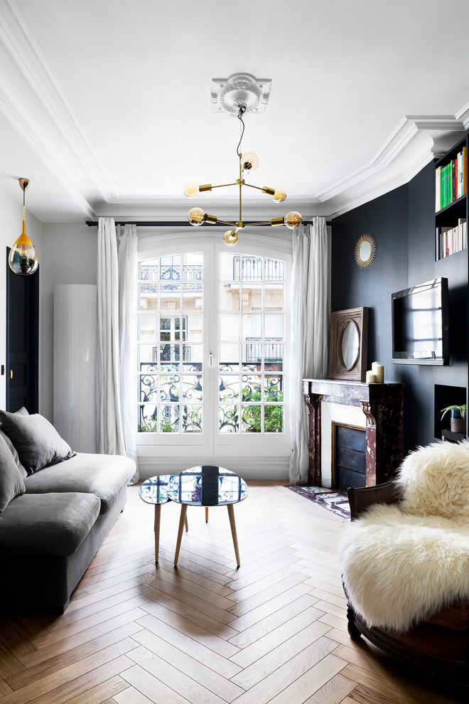 Esempio di un grande soggiorno minimal aperto con camino classico, TV a parete, sala formale, pareti bianche e parquet chiaro