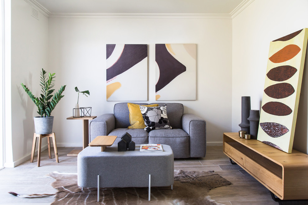 Immagine di un soggiorno contemporaneo con sala formale, pareti bianche, pavimento in legno massello medio e pavimento marrone