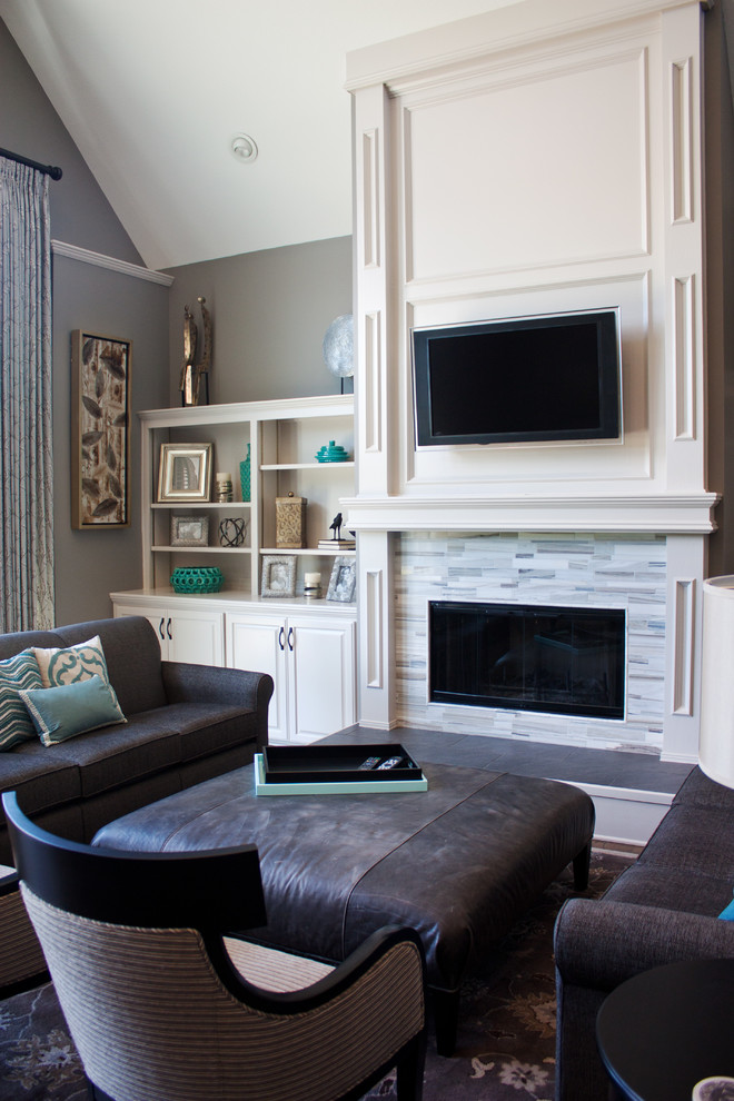 Стильный дизайн: открытая гостиная комната в классическом стиле с серыми стенами, паркетным полом среднего тона, стандартным камином, фасадом камина из плитки и телевизором на стене - последний тренд