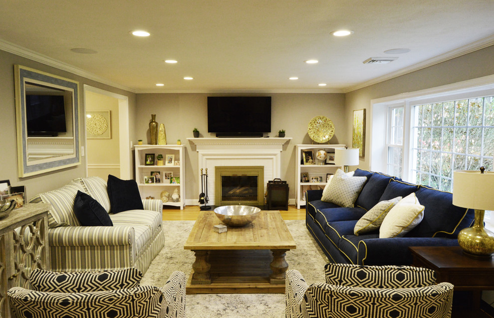 Exempel på ett stort klassiskt separat vardagsrum, med grå väggar, ljust trägolv, en standard öppen spis, en spiselkrans i metall, en väggmonterad TV och beiget golv