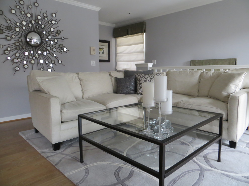 Immagine di un piccolo soggiorno contemporaneo aperto con pareti grigie, TV a parete e pavimento in laminato