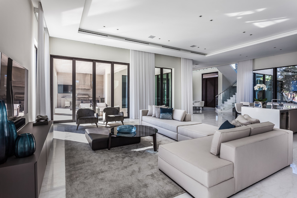Immagine di un soggiorno contemporaneo aperto con pareti bianche, TV a parete e pavimento bianco