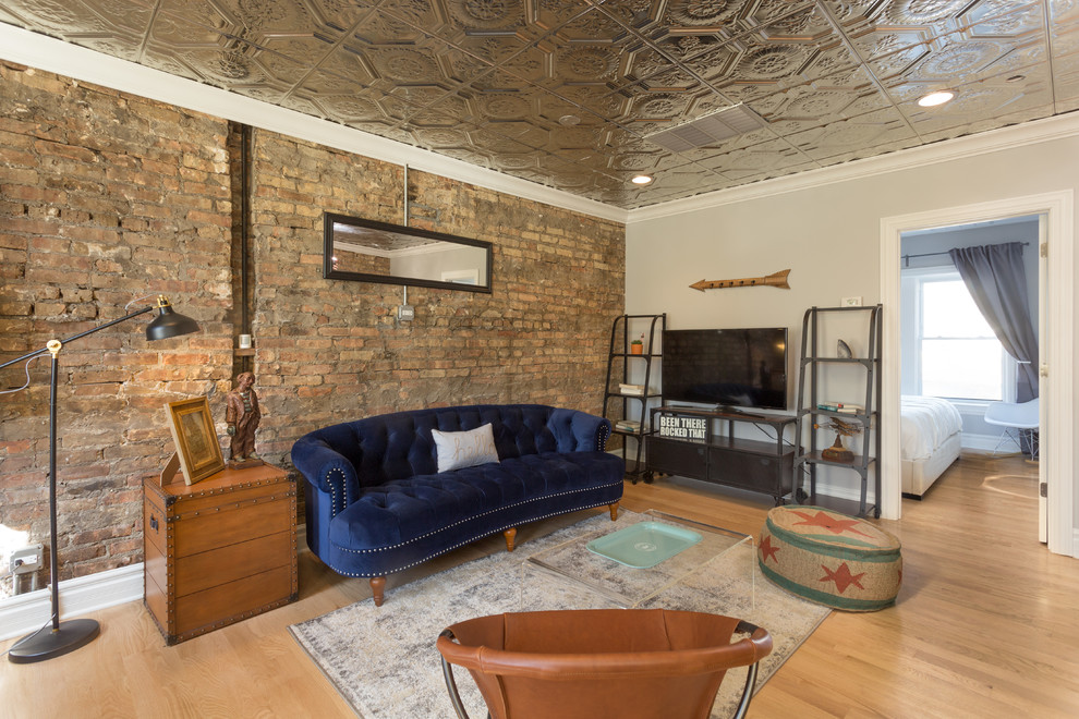 Modelo de salón para visitas tipo loft ecléctico de tamaño medio sin chimenea con paredes beige, suelo de madera en tonos medios y televisor independiente