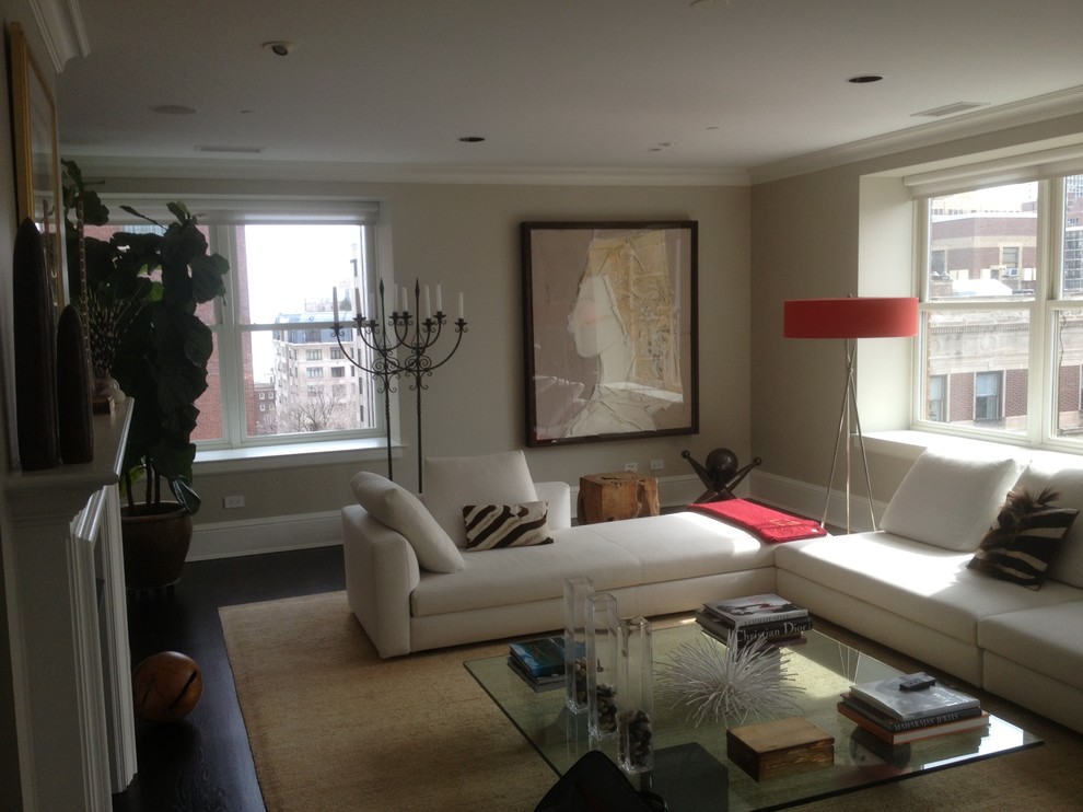 Großes, Fernseherloses, Abgetrenntes Modernes Wohnzimmer mit beiger Wandfarbe, dunklem Holzboden, Kamin, verputzter Kaminumrandung und braunem Boden in Chicago