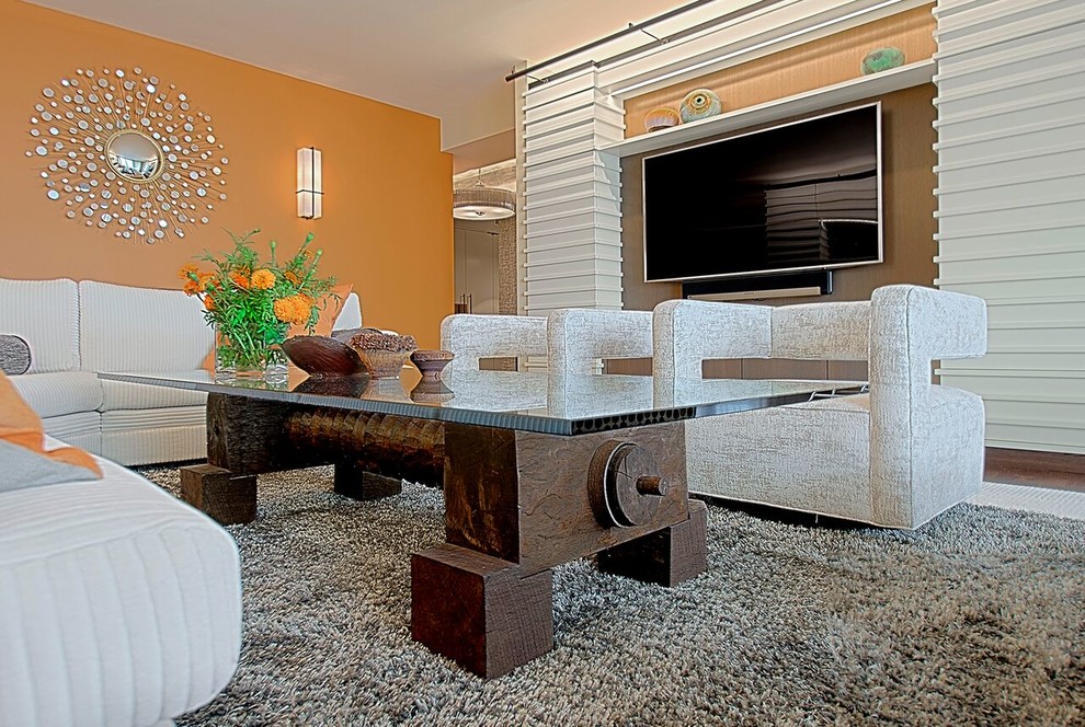 Esempio di un grande soggiorno minimal chiuso con pareti arancioni, parquet scuro, nessun camino, parete attrezzata e pavimento marrone