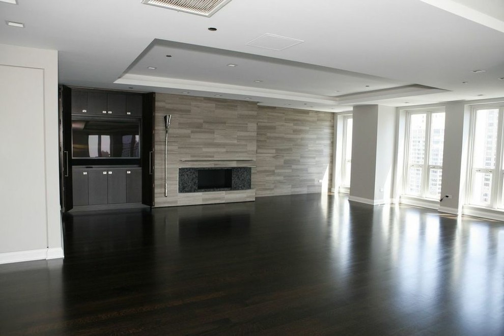 Example of a large trendy formal and open concept dark wood floor living room design in Chicago with gray walls, a ribbon fireplace, a stone fireplace and a media wall