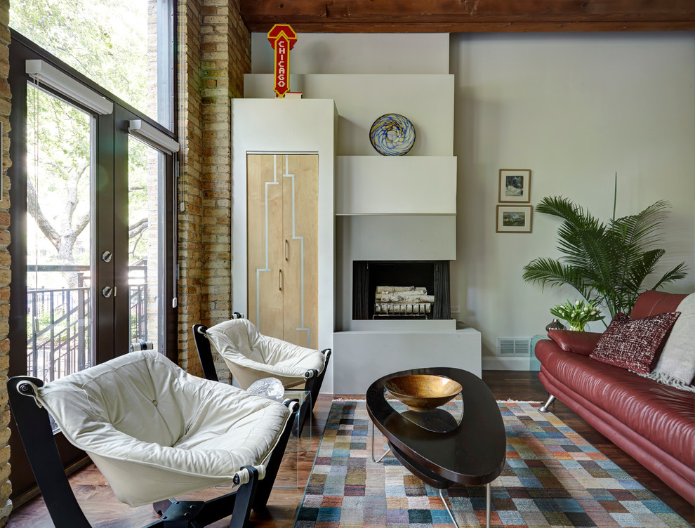 Example of a mid-sized trendy loft-style medium tone wood floor living room library design in Chicago with white walls, a corner fireplace, a concrete fireplace and a concealed tv