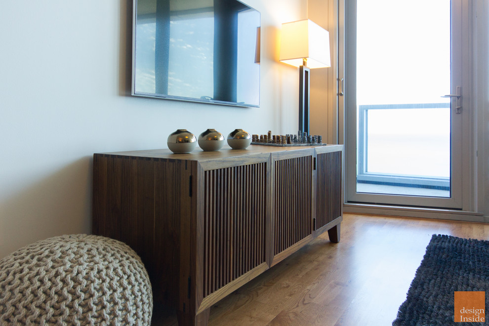 Foto di un soggiorno moderno di medie dimensioni e aperto con angolo bar, pareti beige, pavimento in legno massello medio, nessun camino e TV a parete