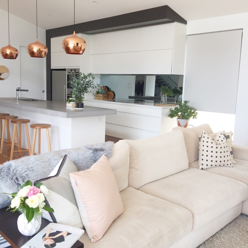 Cette image montre un grand salon minimaliste ouvert avec un sol en bois brun, un manteau de cheminée en carrelage et un téléviseur fixé au mur.