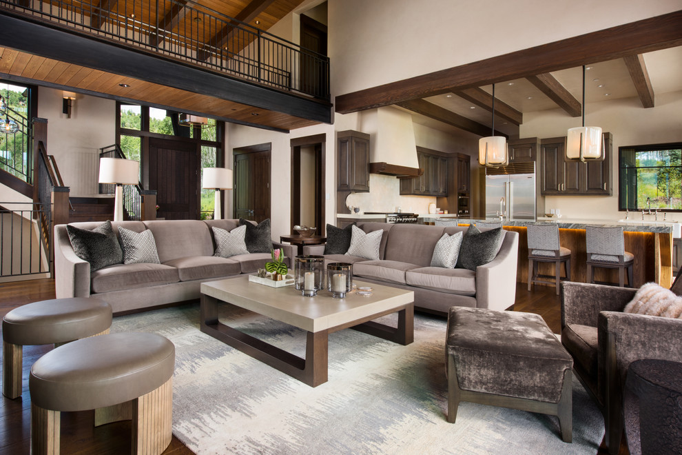Cette photo montre un grand salon mansardé ou avec mezzanine chic avec une salle de réception, un mur beige et un sol en bois brun.