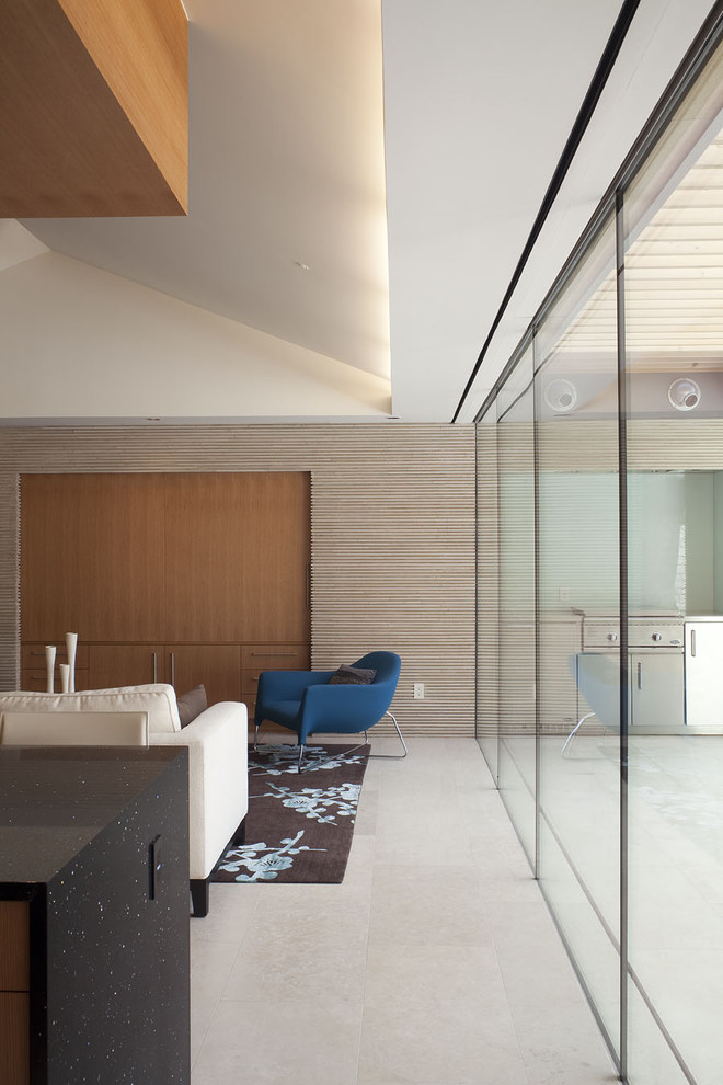Idée de décoration pour un salon minimaliste de taille moyenne et ouvert avec un mur beige, un sol en calcaire et un téléviseur dissimulé.