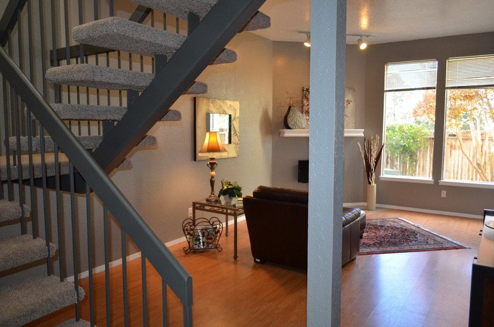 Mittelgroßes, Offenes Modernes Wohnzimmer mit Hausbar, grauer Wandfarbe und Hängekamin in Albuquerque