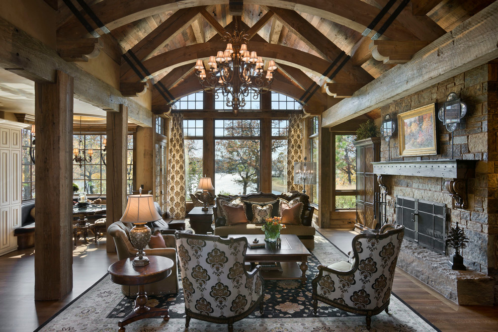 Идея дизайна: большая гостиная комната в стиле рустика с стандартным камином и фасадом камина из камня