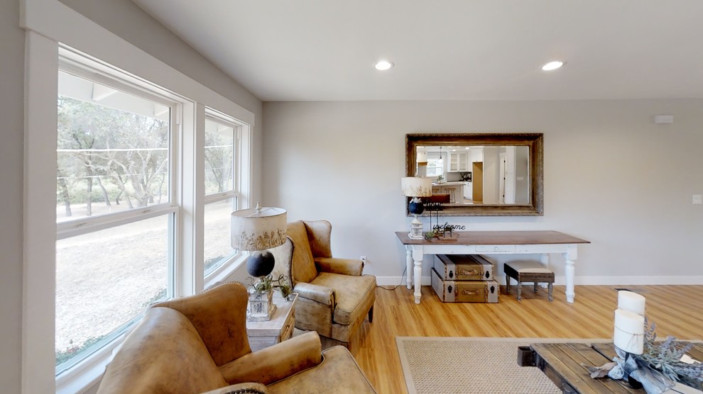 Großes, Offenes Landhaus Wohnzimmer mit grauer Wandfarbe, Laminat, TV-Wand und braunem Boden in Sacramento