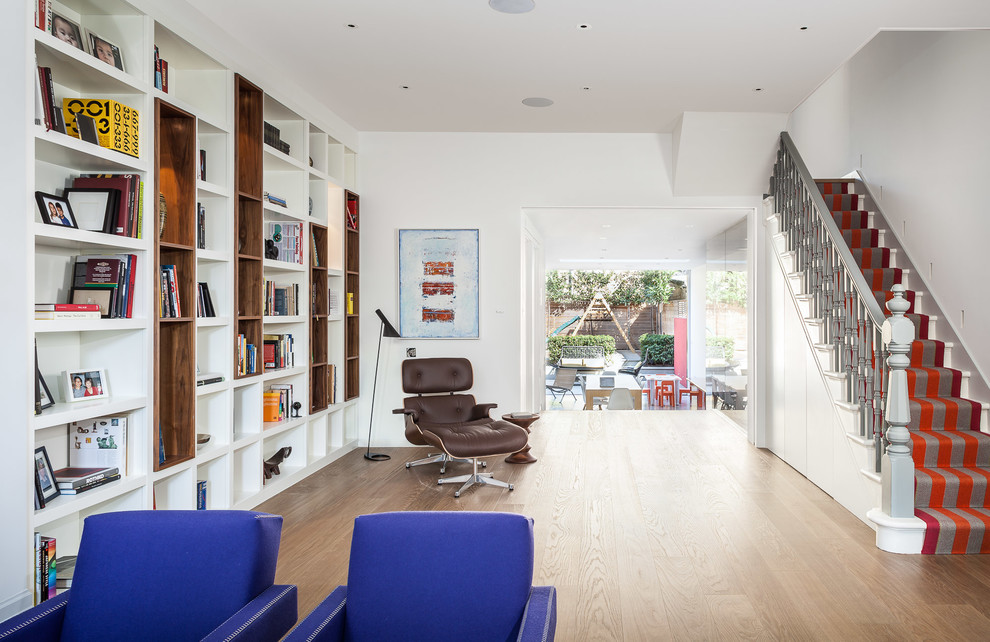 Large contemporary open plan living room in London with white walls and light hardwood flooring.